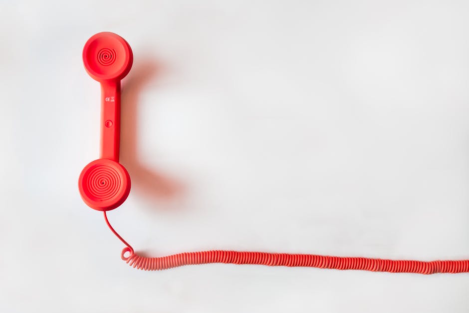 customer advocacy programs - Vintage red phone handset with coiled cable on a clean white background, classic communication device.