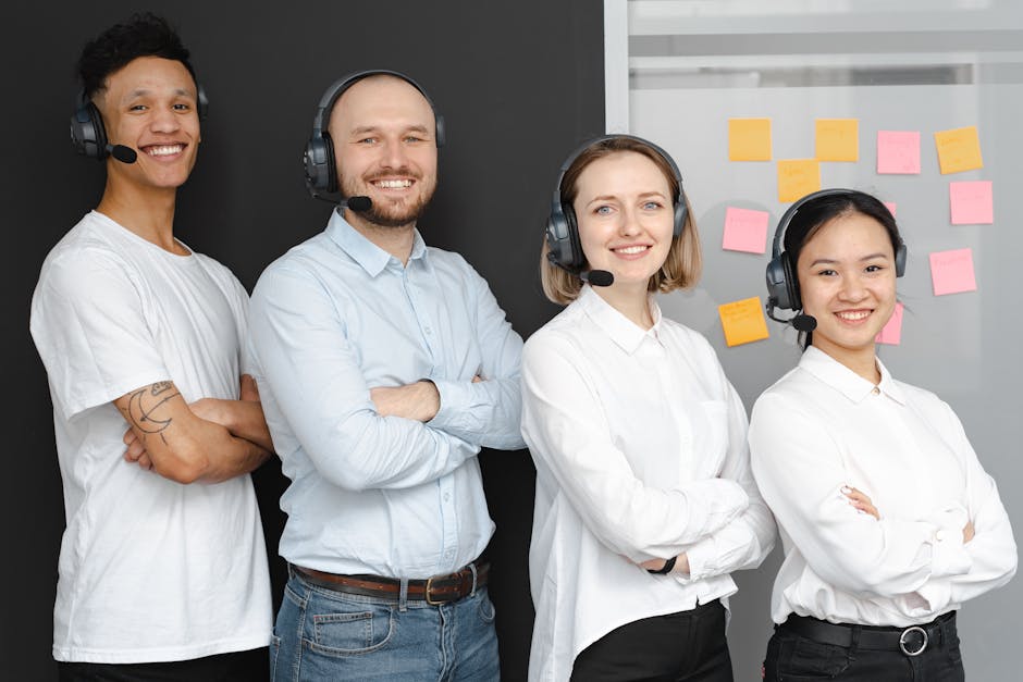 customer advocacy programs - Team of diverse call center professionals smiling and standing confidently with headsets and microphones.