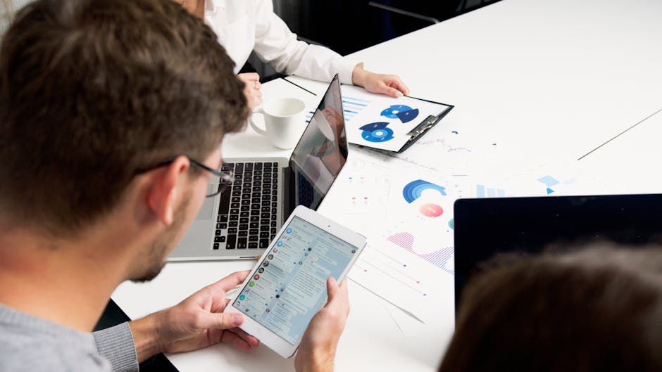 referral marketing for SaaS - Modern team collaboration in office with laptops and tablets focusing on charts and communication.