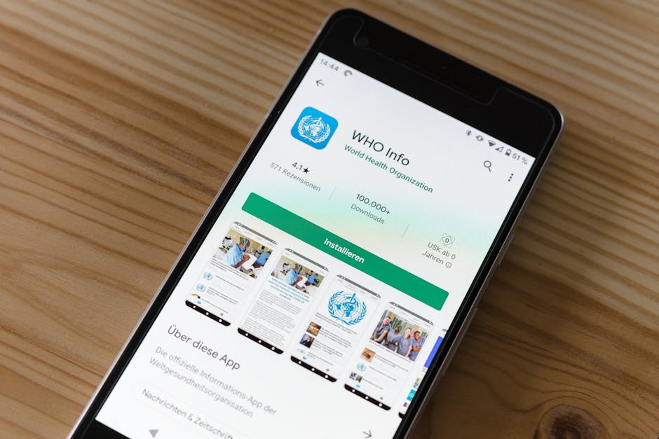in-app referral patterns - Mobile phone on wooden table showing installation screen for WHO Info app from World Health Organization.