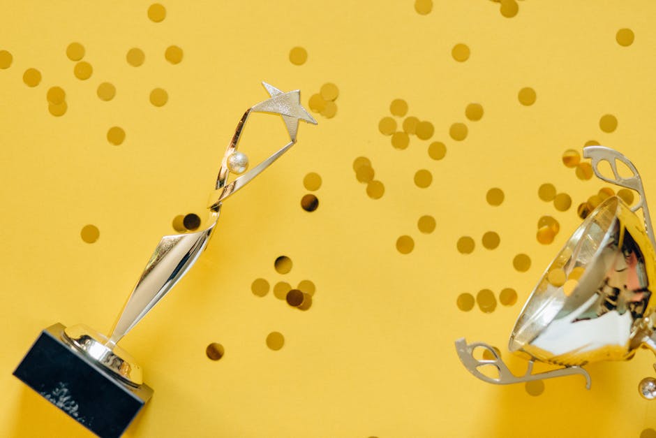 loyalty points program mechanics - Golden trophy with celebratory confetti on a vibrant yellow background.
