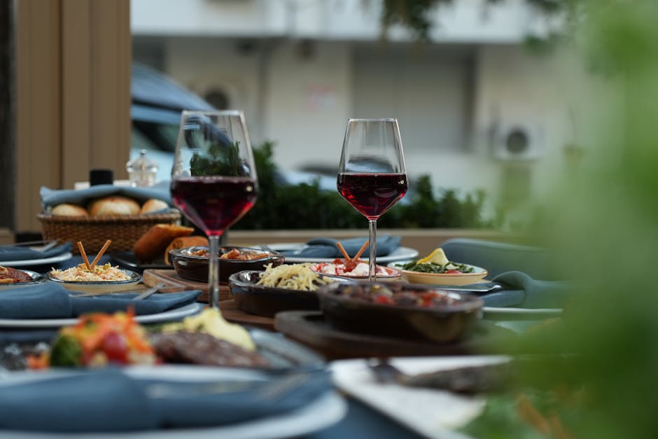 restaurant referral marketing - Luxurious outdoor table setting featuring red wine and a variety of gourmet dishes for a sophisticated dining experience.