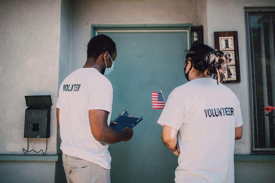 charity donation referral rewards - Two volunteers wear masks and visit community homes, engaging in outreach activities.
