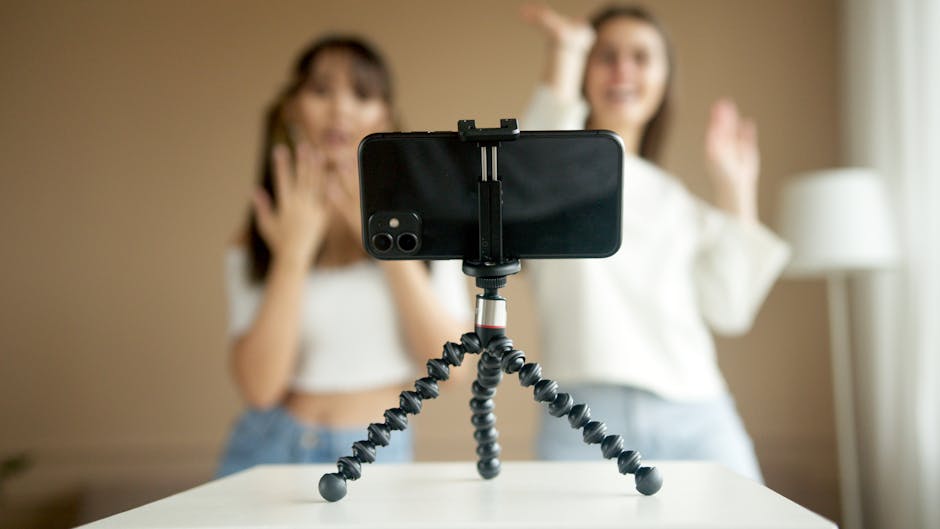 UGC creator program - Two women recording a dance video using a smartphone on a tripod at home.