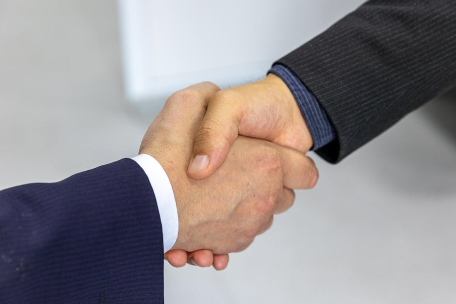 referral marketing news May 2026 - Close-up of two businessmen shaking hands, symbolizing agreement and partnership.