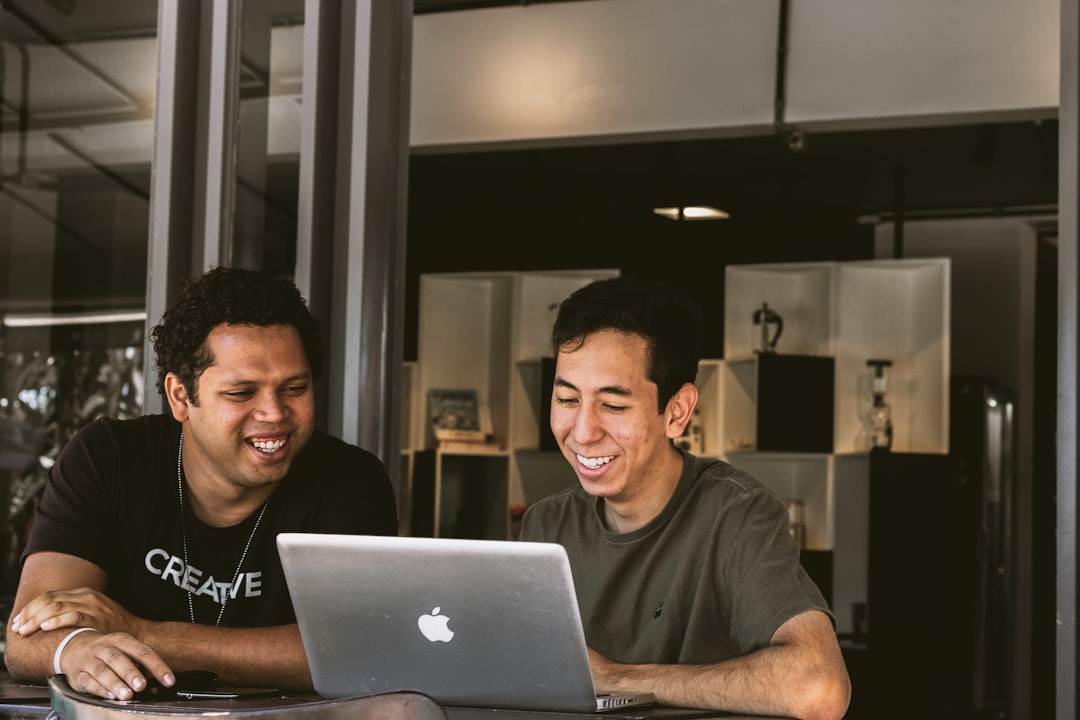 affiliate marketing news - two smiling men looking at MacBook