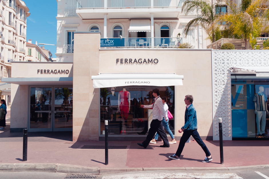referral and affiliate marketing - Sunny day view of Ferragamo store in Cannes, France with pedestrians passing by.