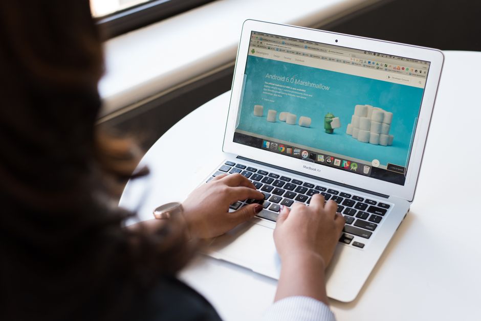 cloudways vs shared hosting - Businesswoman working on laptop with Android 6.0 Marshmallow webpage open.