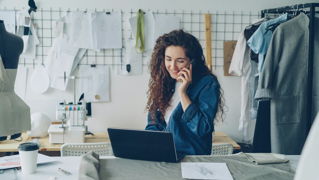affiliate marketing news - Fashion designer on the phone, working on a laptop