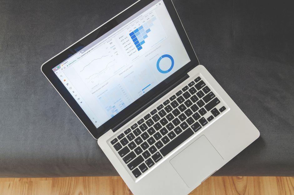 small business marketing - Overhead view of a laptop showing data visualizations and charts on its screen.